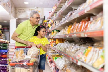 Father and his pretty daughter are choosing household objects while doing shopping in supermarket