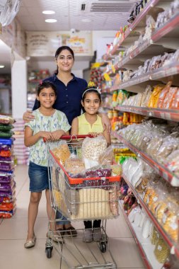 Mother and daughters shopping in supermarket
