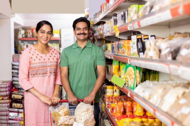 Couple at grocery aisle while shopping at supermarket