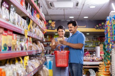 Couple at grocery aisle while shopping at supermarket.