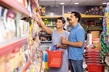 Couple at grocery aisle while shopping at supermarket.