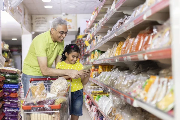 Süpermarkette alışveriş yaparken market koridorunda mutlu bir aile.