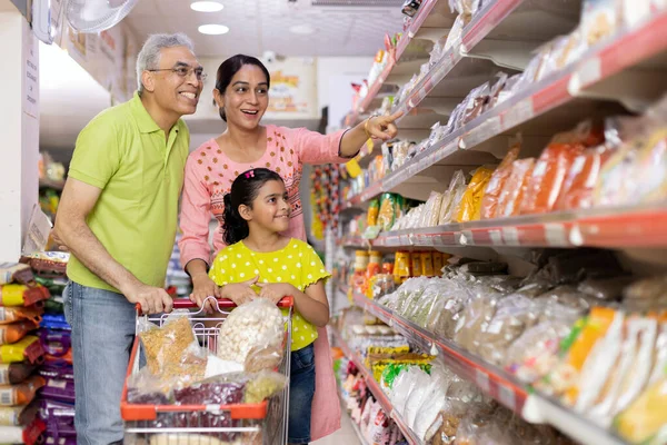 Süpermarkette alışveriş yaparken market koridorunda mutlu bir aile.