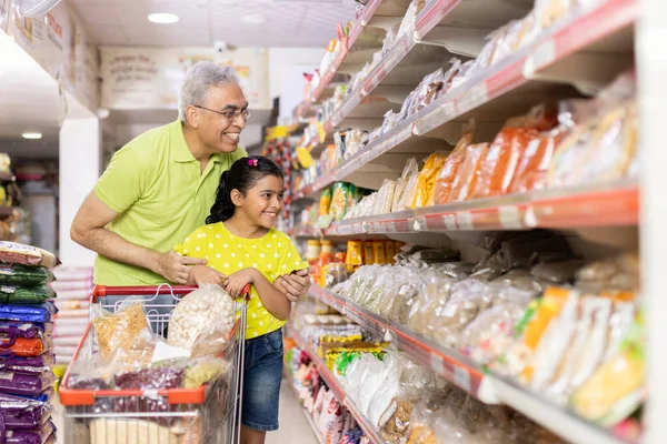 Baba ve güzel kızı markette alışveriş yaparken ev eşyaları seçiyorlar.