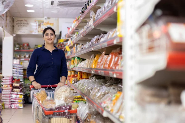 Kadınlar süpermarkette alışveriş yaparken ürün bilgileri okuyorlar.