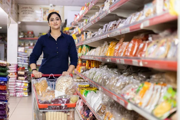 Kadınlar süpermarkette alışveriş yaparken ürün bilgileri okuyorlar.