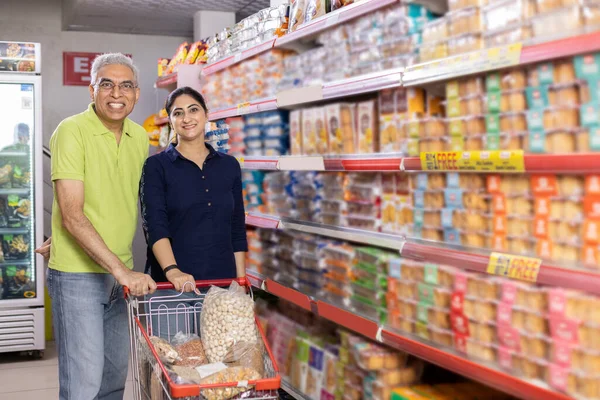 Portrait of indian couple at grocery store while shopping.