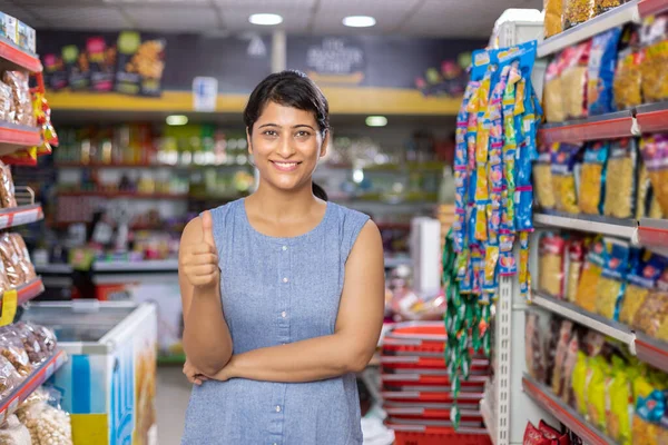 Mağazada başparmak gösteren mutlu kadın.