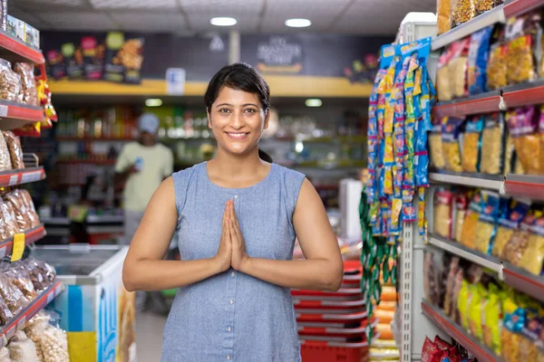 Süpermarket koridorunda Namaste 'ı selamlayan Hintli bir kadının portresi.