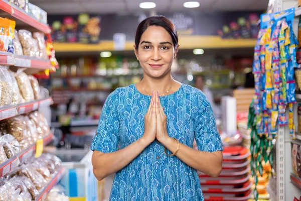 Süpermarket koridorunda Namaste 'ı selamlayan Hintli bir kadının portresi.