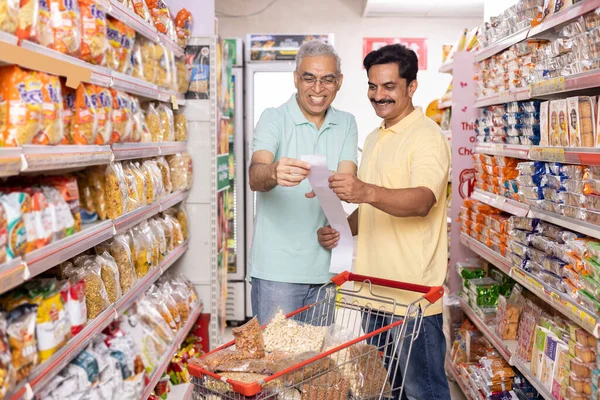 Elderly father and mature son shopping at store