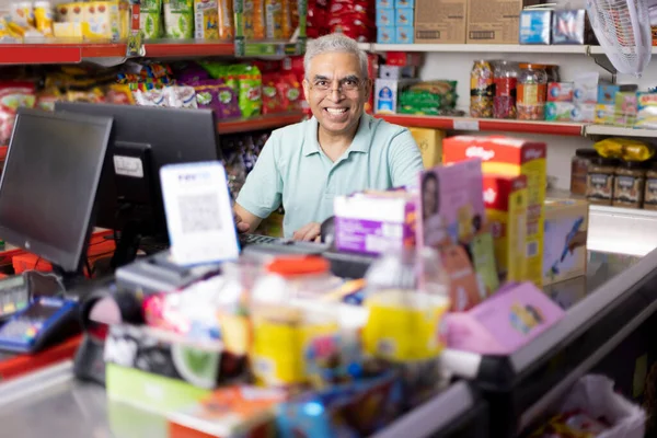 Happy man working as a cashier at supermarket