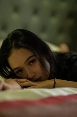 Asyalı kadınlar üzgün bir ifade takınırlar. Yatak odasında yalnız başına yatarken bir şey düşünmek gibi.