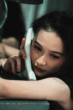 Bir kadın bir telefon tutuyor ve bir suç için polisi ararken kulağına dayıyor.