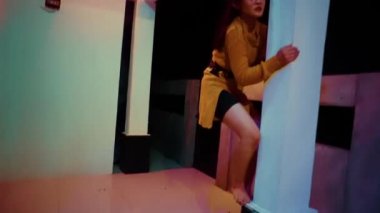 Asian Woman Climbing the wall fence while dancing using orange clothes in dark night