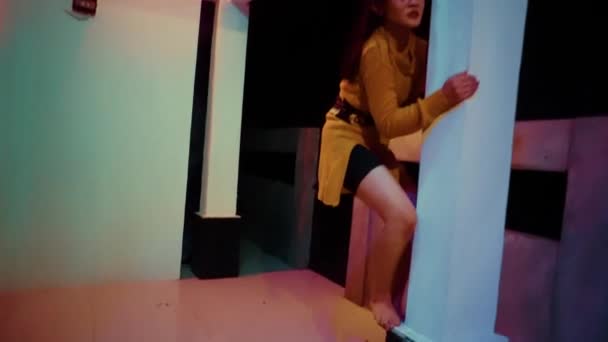 Ασιάτισσα Γυναίκα Σκαρφαλώνει Στο Φράχτη Ενώ Χορεύει Πορτοκαλί Ρούχα Σκοτεινή — Αρχείο Βίντεο