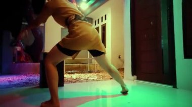 Asian women dancing on the terrace floor in front of the house at the night