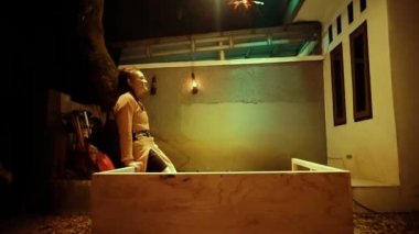 Depression Asian Woman dancing at the table in front of the house while wearing orange clothes