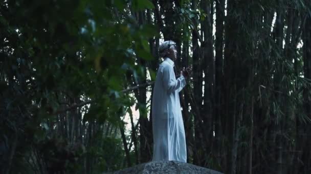 Muslim Man Praying Forest While Standing Big Rock Wearing White — Vídeo de Stock