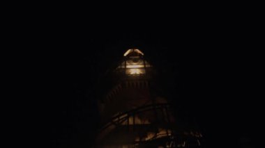 Beautiful palace in the dark night with the warm lighting and a huge tower inside the castle