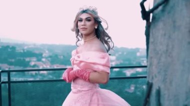 A Beautiful Princess in a pink wedding dress enjoying the air on the rooftop with a black fence
