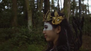 Chinese woman in Halloween costume walking lonely in the forest