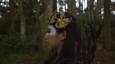 Chinese woman in Halloween costume walking lonely in the forest