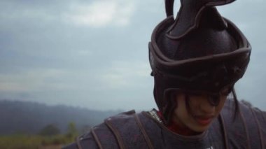 Asian women with armor suits walk with difficulty while climbing a mountain hill with brown soil during the morning