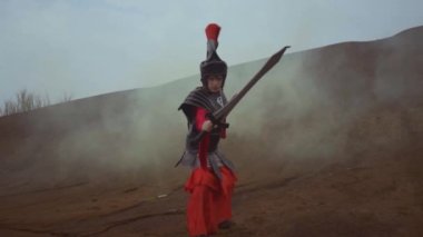 An Armored Asian Woman holding a sword when fighting the enemy in the desert in smoke during the daylight