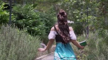 Village girl walking happily in the garden while wearing a princess dress inside the forest