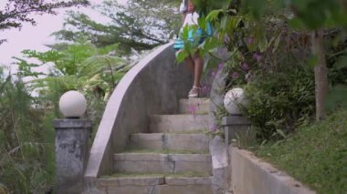 A Princess walking beautifully in the forest while wearing a short blue skirt and a white dress during the morning