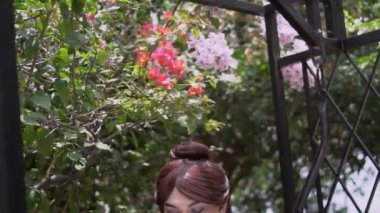A Royal Princess sitting on the swing while reading a letter inside her garden in the palace