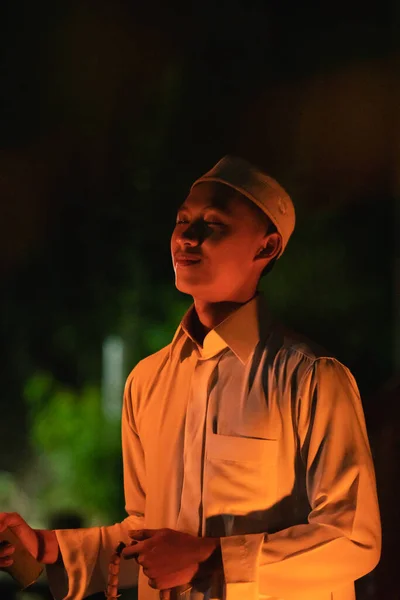 A Muslim man lighten up the campsite with the fire torch in his hands during the dark night