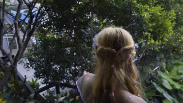 一位穿着粉色连衣裙的公主走下楼梯 走到森林里去 森林里有一朵鲜花和一棵树环绕着她 — 图库视频影像