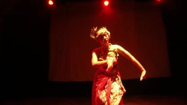 Bir Java dansçısı kendi vücudunun sahne ışığında dans ederken vücudunu ritme göre hareket ettirir.