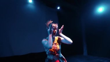 Bir Java dansçısı kendi vücudunun sahne ışığında dans ederken vücudunu ritme göre hareket ettirir.