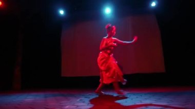 Bir Java dansçısı kendi vücudunun sahne ışığında dans ederken vücudunu ritme göre hareket ettirir.
