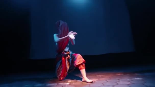 スカーフダンサーは 暗い夜だけで彼女の体と一緒に移動しながら 彼女の顔をカバーするために赤い服を使用します — ストック動画