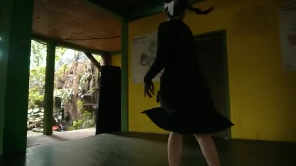 黄色い部屋の中に黒いスーツを着ている間 彼女の顔に白い布で踊っている盲目の女性 — ストック動画