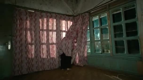 貧しい家の赤いカーテンの前で赤い服を着ている間 アジアの女性は木の棒で踊るブラインド — ストック動画