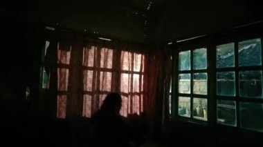 Kırmızı perdeyle dans eden kör Asyalı kadın geleneksel evde öfkeyle dans ediyor.