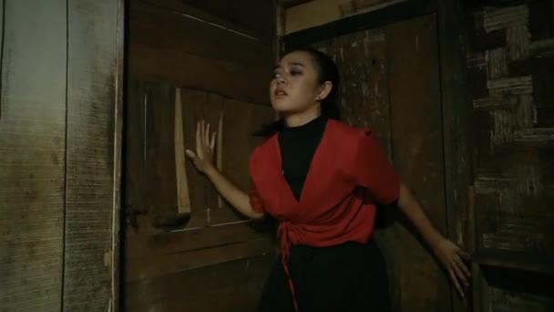 伝統的な家の中の角に竹の扉の前に隠れていると アジア系の盲人女性が怪我をしている — ストック動画
