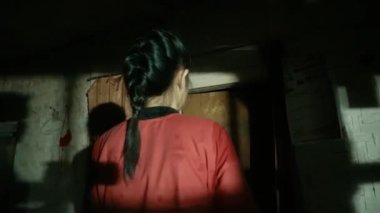 Kör kadın elinde sopayla kapıda yürüyordu. Zavallı evinde kırmızı bir gömlek giyiyordu.