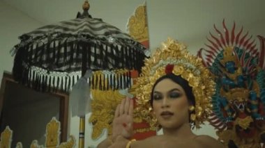 Süslü bir kapının önünde dans eden güzel bir Balili kadın. Tapınağın içinde kafasında altın bir taç var.