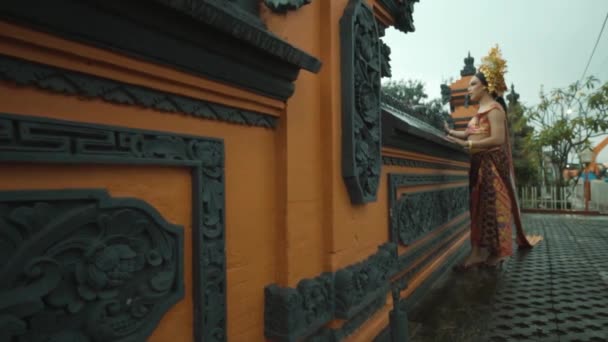 Прекрасна Балійська Жінка Стоїть Помаранчевій Стіні Носячи Традиційний Балійський Костюм — стокове відео