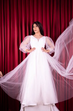 Beyaz Saray 'daki kırmızı perdenin önünde pahalı bir gelinlikle poz veren güzel Asyalı kadın.