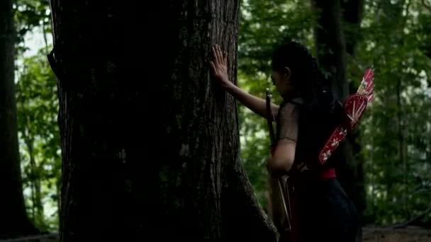 茶色の木に急いで走っている黒いドレスの女性 息切れや森の中で疲れています — ストック動画