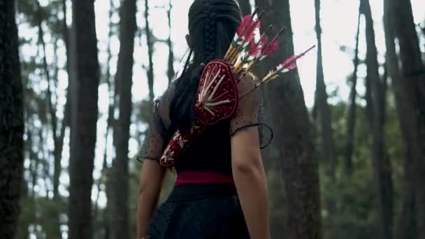 正午に敵の弓と矢を盗んで森から逃げるアジアの少女 — ストック動画