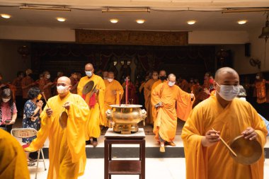 Bandung, Endonezya - 8 Ocak 2022: Keşişler Çin 'deki Buda tapınağındaki ibadet töreni başlamadan önce tapınağı ziyaret etmek için birlikte yürüdüler.