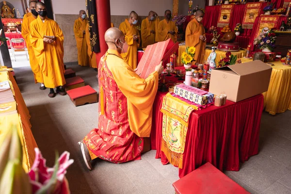 インドネシア バンドン 2022年1月8日仏寺内の祭壇前でオレンジの服を着た僧侶が一緒に祈る — ストック写真